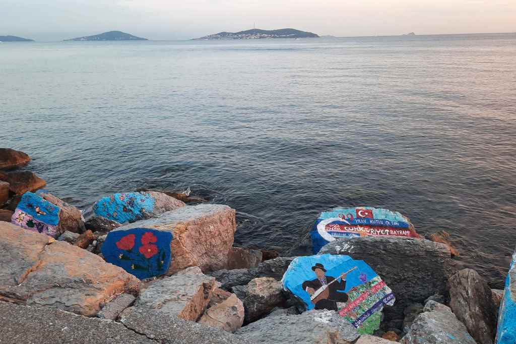 Colorful painted rocks placed along a Turkish shoreline, combining natural beauty with local creativity.
