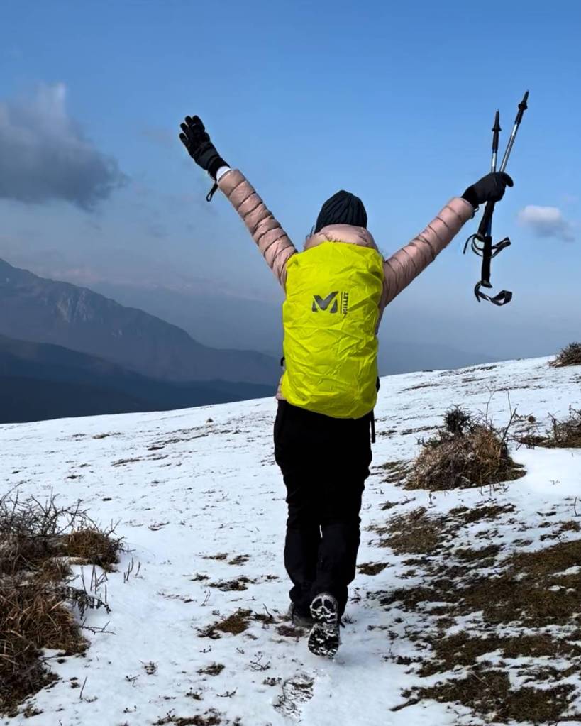 hiking through a snow-covered trail, wearing a backpack and winter gear